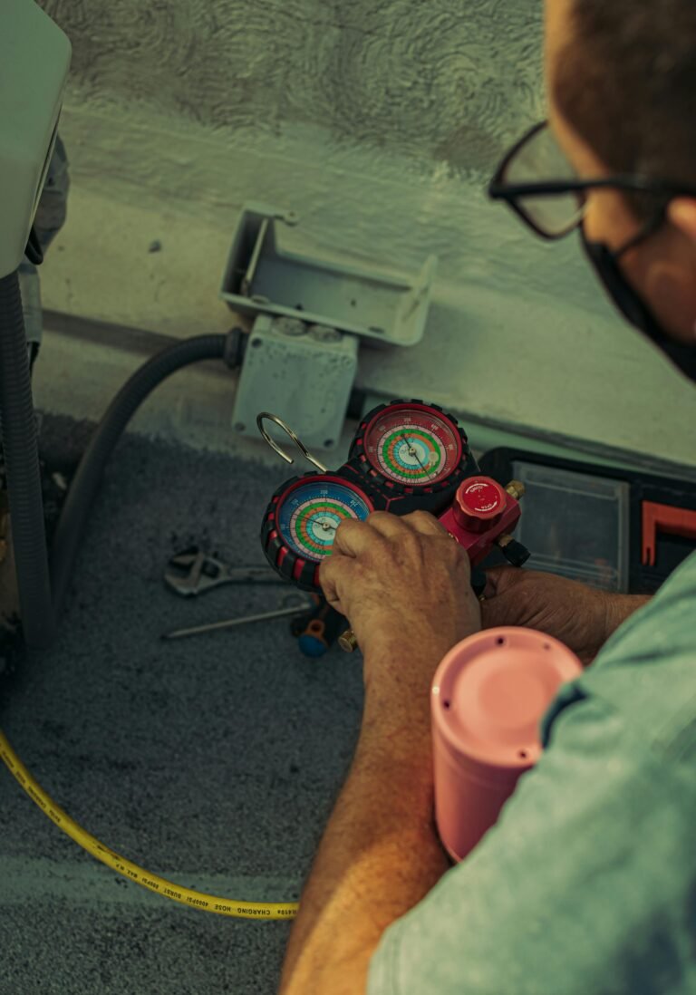 Professional technician adjusting a refrigerant manifold gauge for air conditioning maintenance.